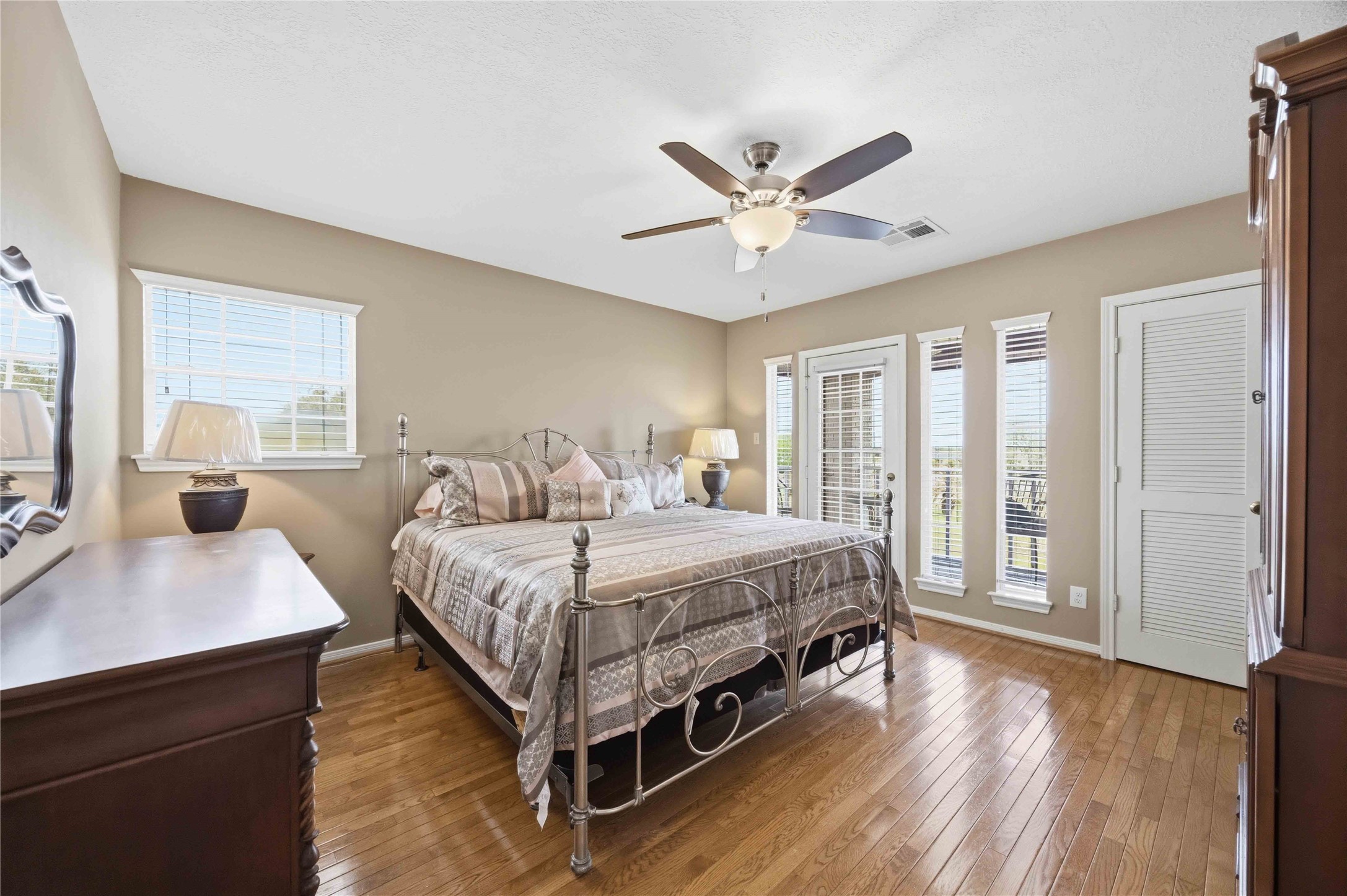 12075 Farm To Market 359 Hempstead, TX 77445 - Photo 34 of 46 a bedroom with a large bed a chandelier and windows