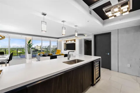 a kitchen with stainless steel appliances kitchen island granite countertop a sink counter space and living room view