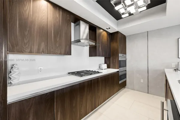 a kitchen with stainless steel appliances granite countertop a stove a refrigerator and a sink with wooden cabinets