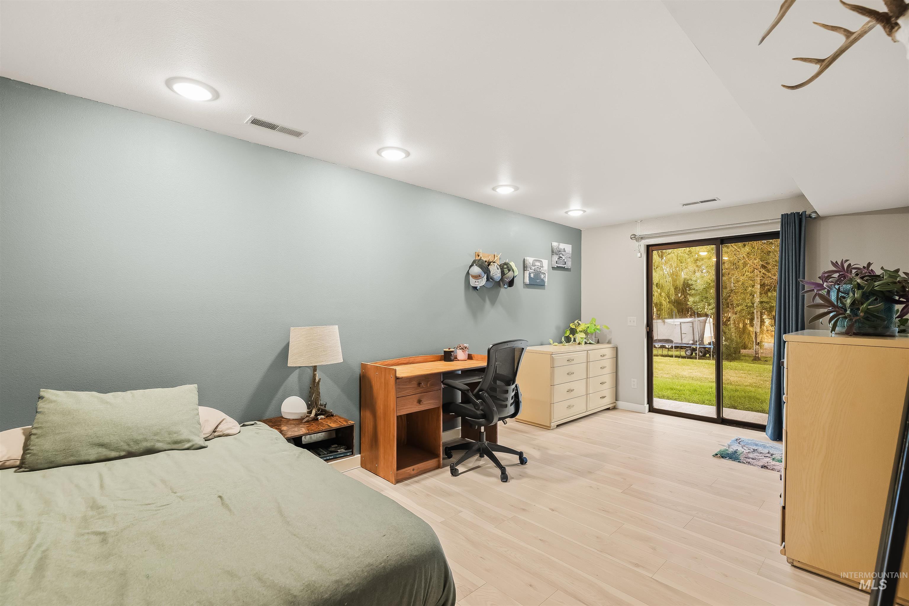 2048 Arborcrest Road Moscow, ID 83843 - Photo 38 of 50 Recessed lighting, light wood-finish flooring, sliding glass door, and pale blue accent wall