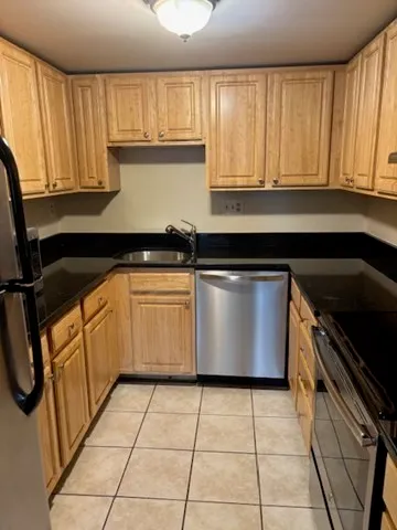 a kitchen with stainless steel appliances granite countertop a sink stove and cabinets