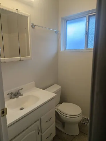 a bathroom with a sink mirror vanity and toilet