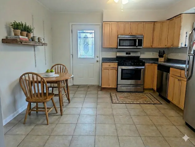 a kitchen with granite countertop a sink cabinets and stainless steel appliances