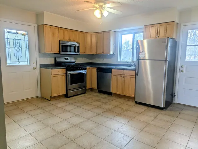 a kitchen with stainless steel appliances granite countertop a refrigerator a stove a sink dishwasher and a refrigerator