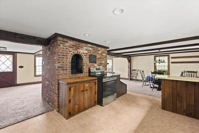 a living room with furniture a large window and stainless steel appliances