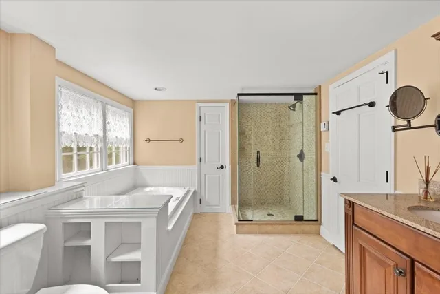 a bathroom with a granite countertop sink a toilet and shower