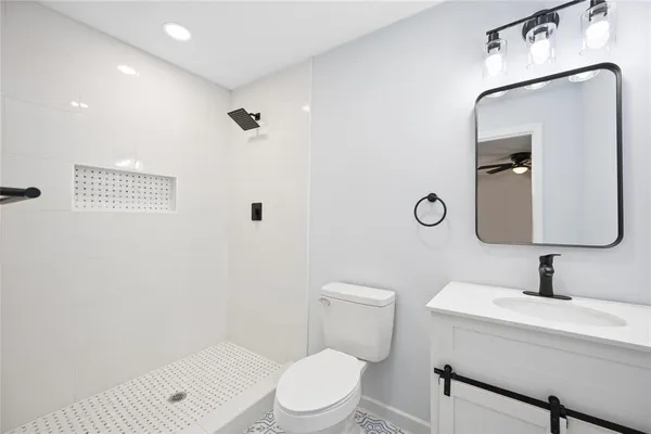 a bathroom with a toilet sink vanity and mirror