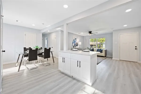 a large white kitchen with lots of counter space and glass door