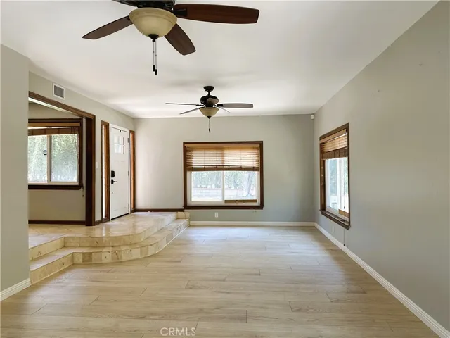 a view of an empty room with a window and fireplace