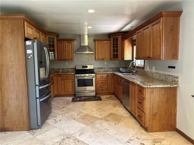 a kitchen with stainless steel appliances granite countertop a stove a sink dishwasher a refrigerator and cabinets