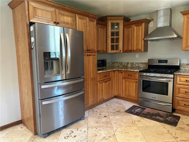 a kitchen with stainless steel appliances granite countertop a refrigerator stove and sink
