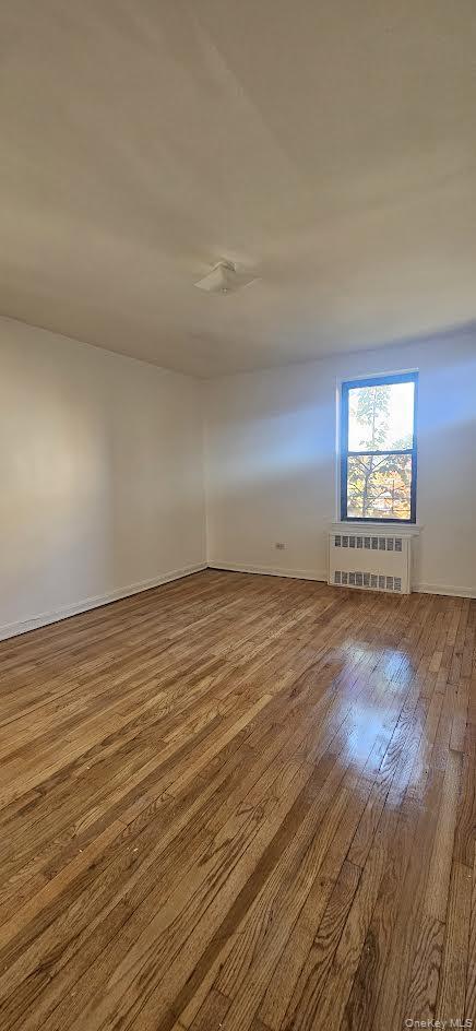 65-35 108th Street, Unit B15 Queens, NY 11375 - Photo 5 of 13 an empty room with wooden floor and windows