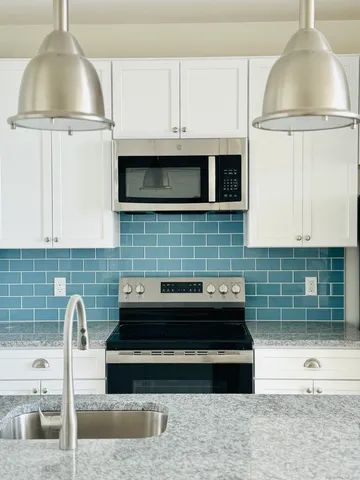 a kitchen with granite countertop a stove and a microwave