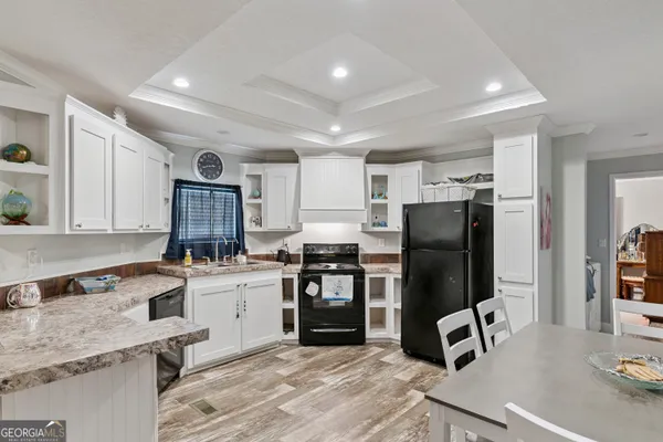 a kitchen with a refrigerator a stove and a sink with wooden floor