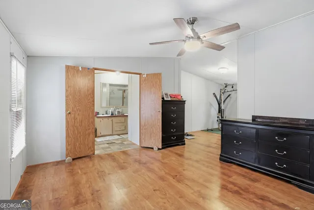a view of an empty room with cabinet and a ceiling fan
