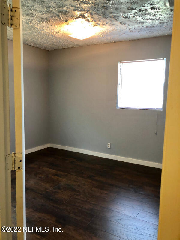 2190 Benedict Road Jacksonville, FL 32209 - Photo 3 of 5 a view of an empty room with wooden floor and a window