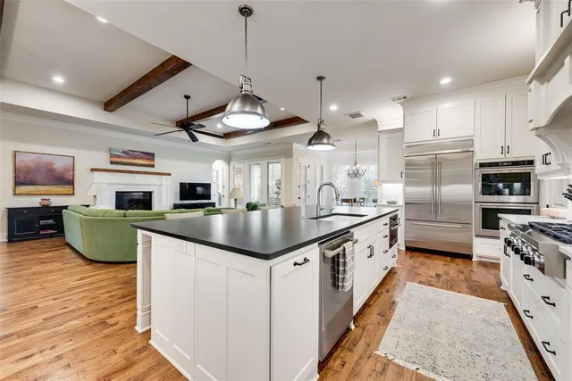 a kitchen with stainless steel appliances kitchen island granite countertop a sink and a refrigerator