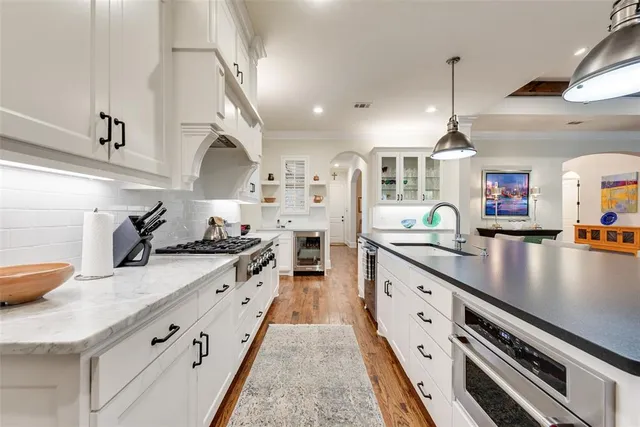a large kitchen with stainless steel appliances granite countertop a lot of counter space and a sink