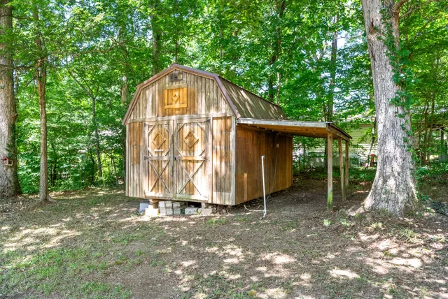 a view of a tiny house with large trees