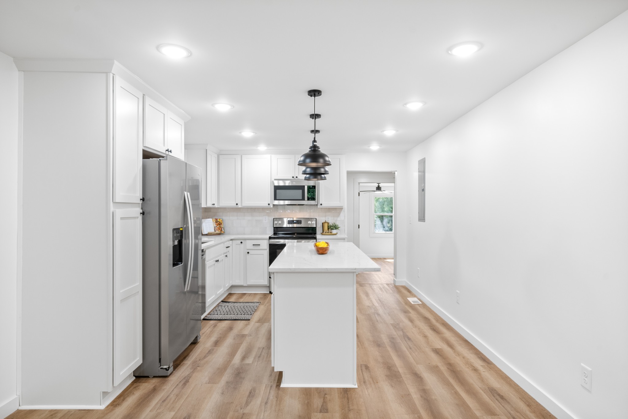 1120 Kingston Springs Road Kingston Springs, TN 37082 - Photo 6 of 20 a kitchen with stainless steel appliances a refrigerator oven a sink dishwasher and white cabinets with wooden floor