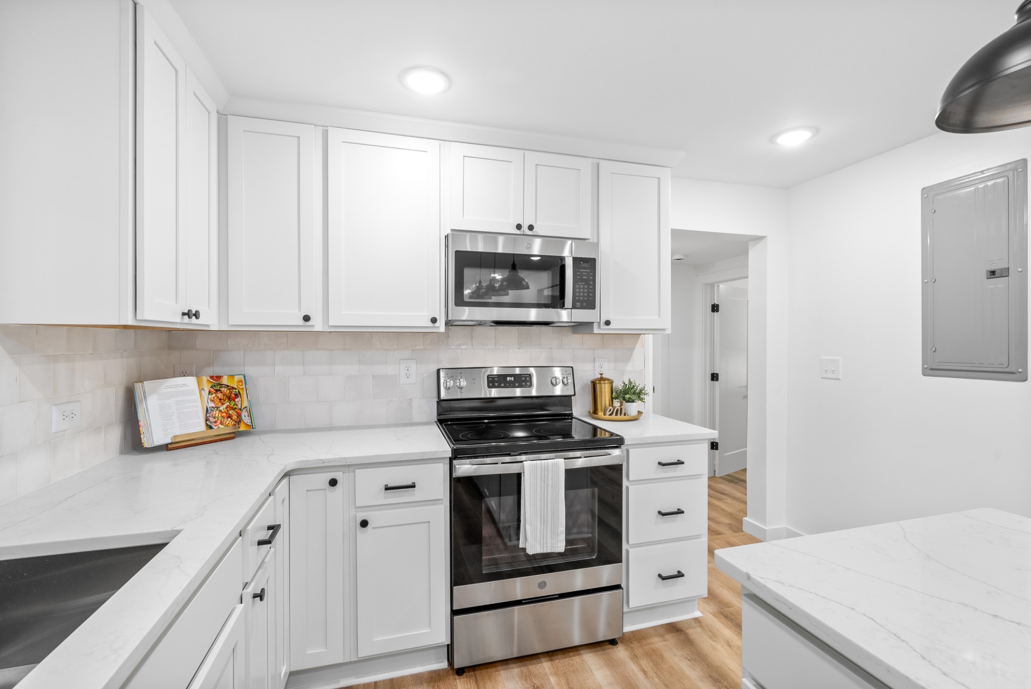 1120 Kingston Springs Road Kingston Springs, TN 37082 - Photo 8 of 20 a kitchen with stainless steel appliances white cabinets and a stove a oven with wooden floors