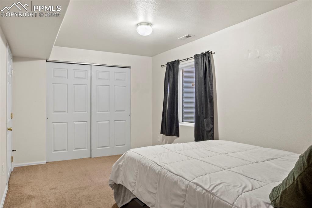 4806 Rusty Nail Point, Unit 101 Colorado Springs, CO 80916 - Photo 31 of 39 a bed sitting in a bedroom and closet