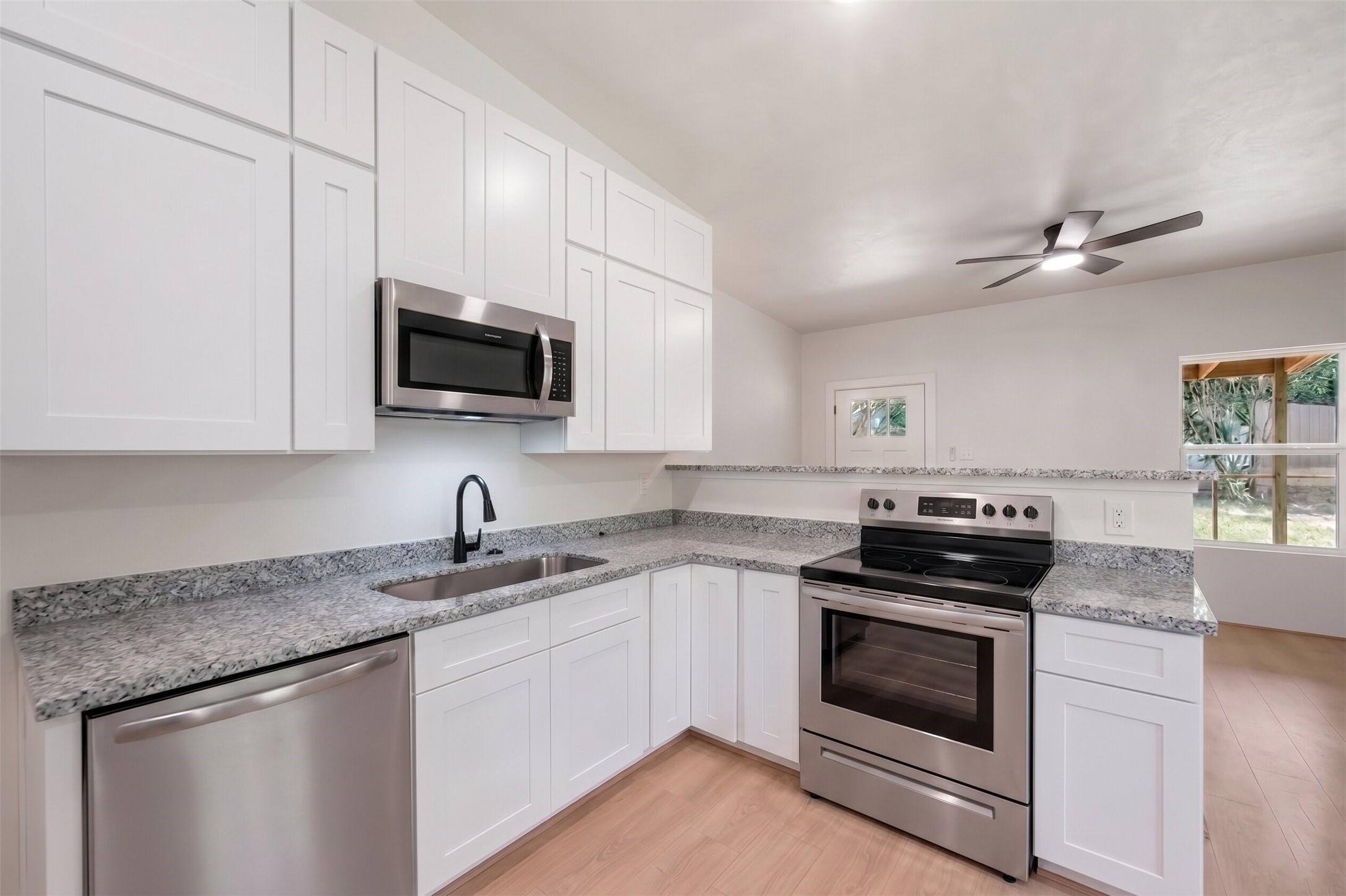 136 Ash Street Trinity, TX 75862 - Photo 5 of 31 a kitchen with granite countertop a stove sink and microwave