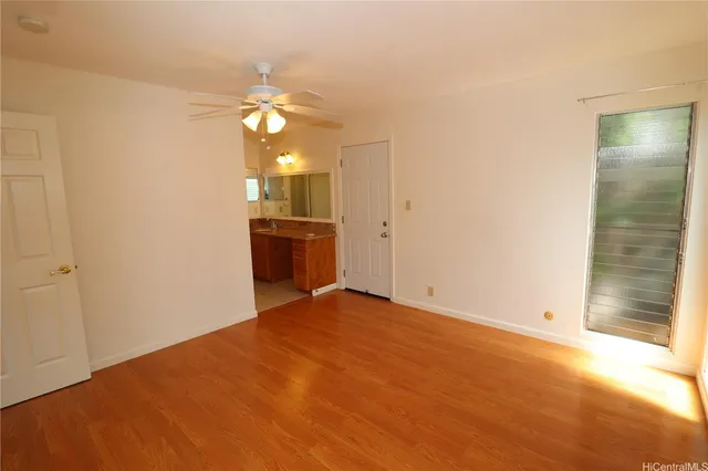 an empty room with fan and entrance