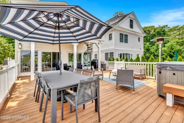 a view of a patio with table and chairs under an umbrella with a small yard
