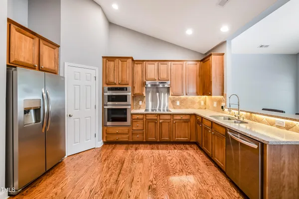 a kitchen with stainless steel appliances granite countertop a refrigerator and a sink