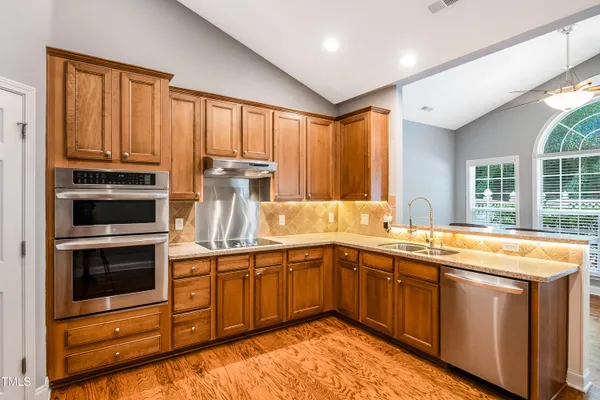 a kitchen with stainless steel appliances granite countertop a sink and dishwasher a stove with cabinets