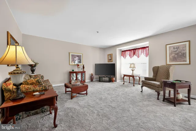 a living room with furniture a desk and a flat screen tv