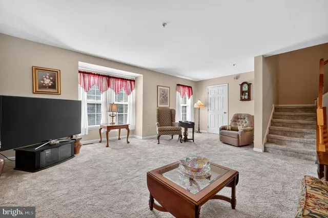 a living room with furniture a flat screen tv and a window