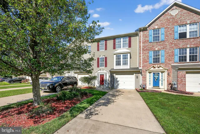 a front view of a house with a garden and trees