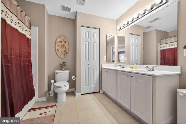 a bathroom with a toilet a sink and a large mirror