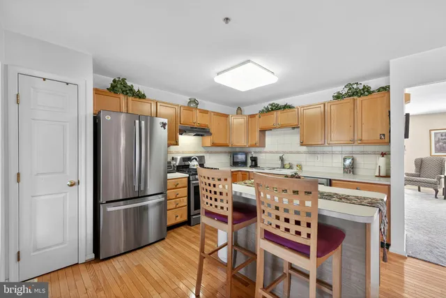 a kitchen with stainless steel appliances a refrigerator stove microwave and white cabinets