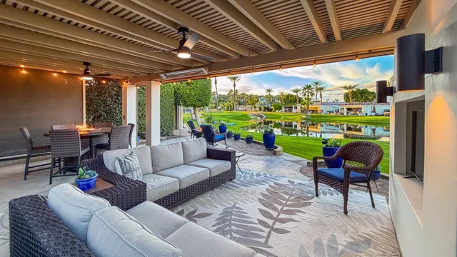 a living room with patio furniture and a garden