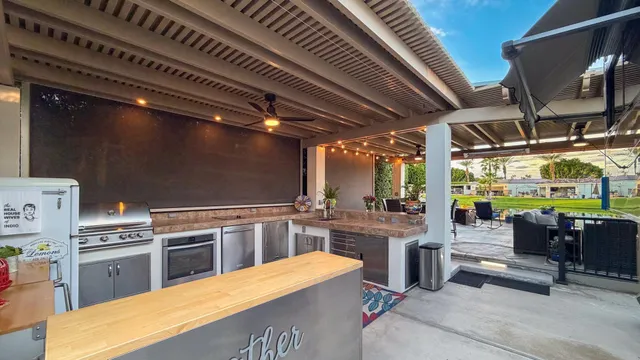 a kitchen with stainless steel appliances kitchen island granite countertop a table chairs and a wooden floors