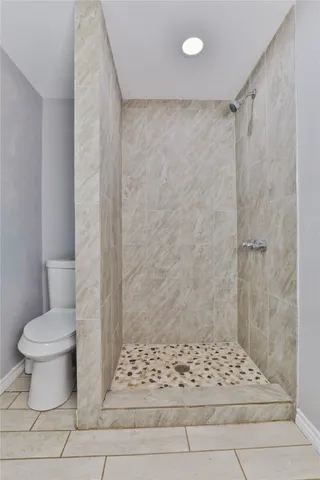 a bathroom with a toilet and a shower