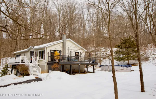 a front view of a house with a yard covered in snow
