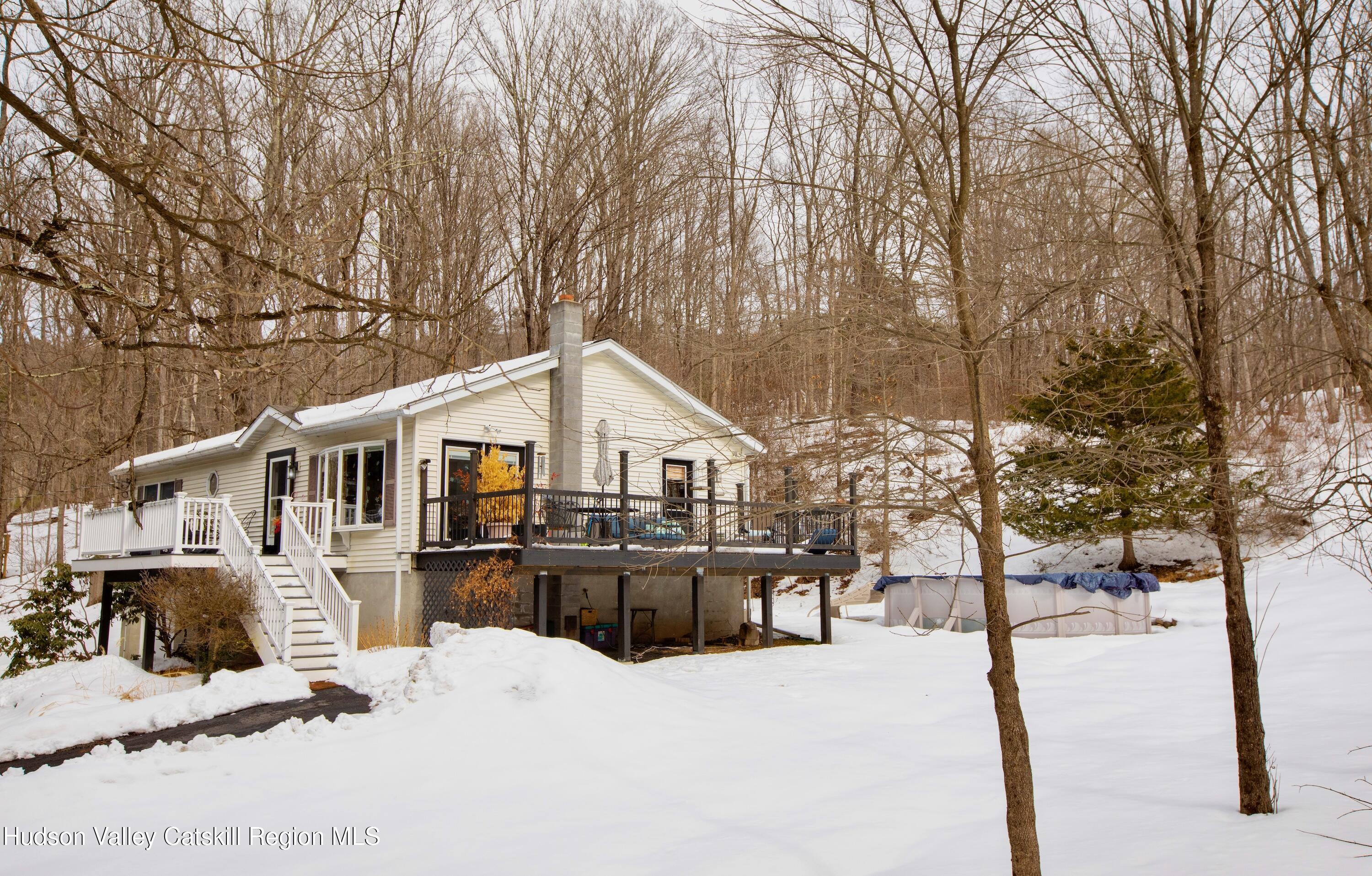 a front view of a house with a yard covered in snow
