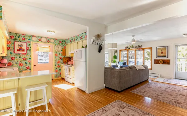 a living room with furniture and a refrigerator