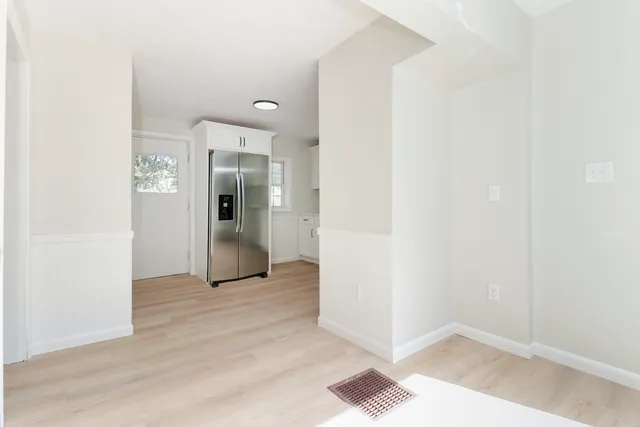 an empty room with wooden floor and a bathroom