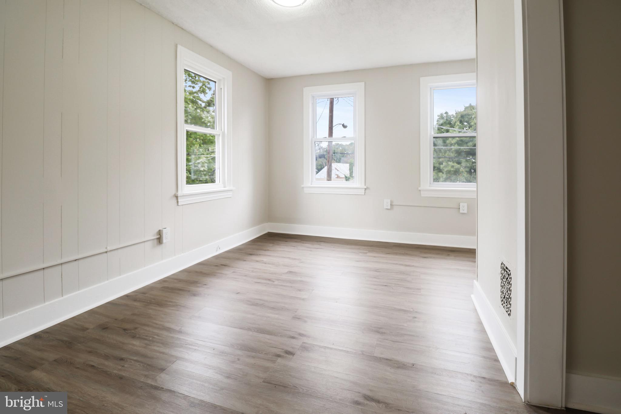 116 8th Street Salem, NJ 08079 - Photo 12 of 16 an empty room with wooden floor and windows