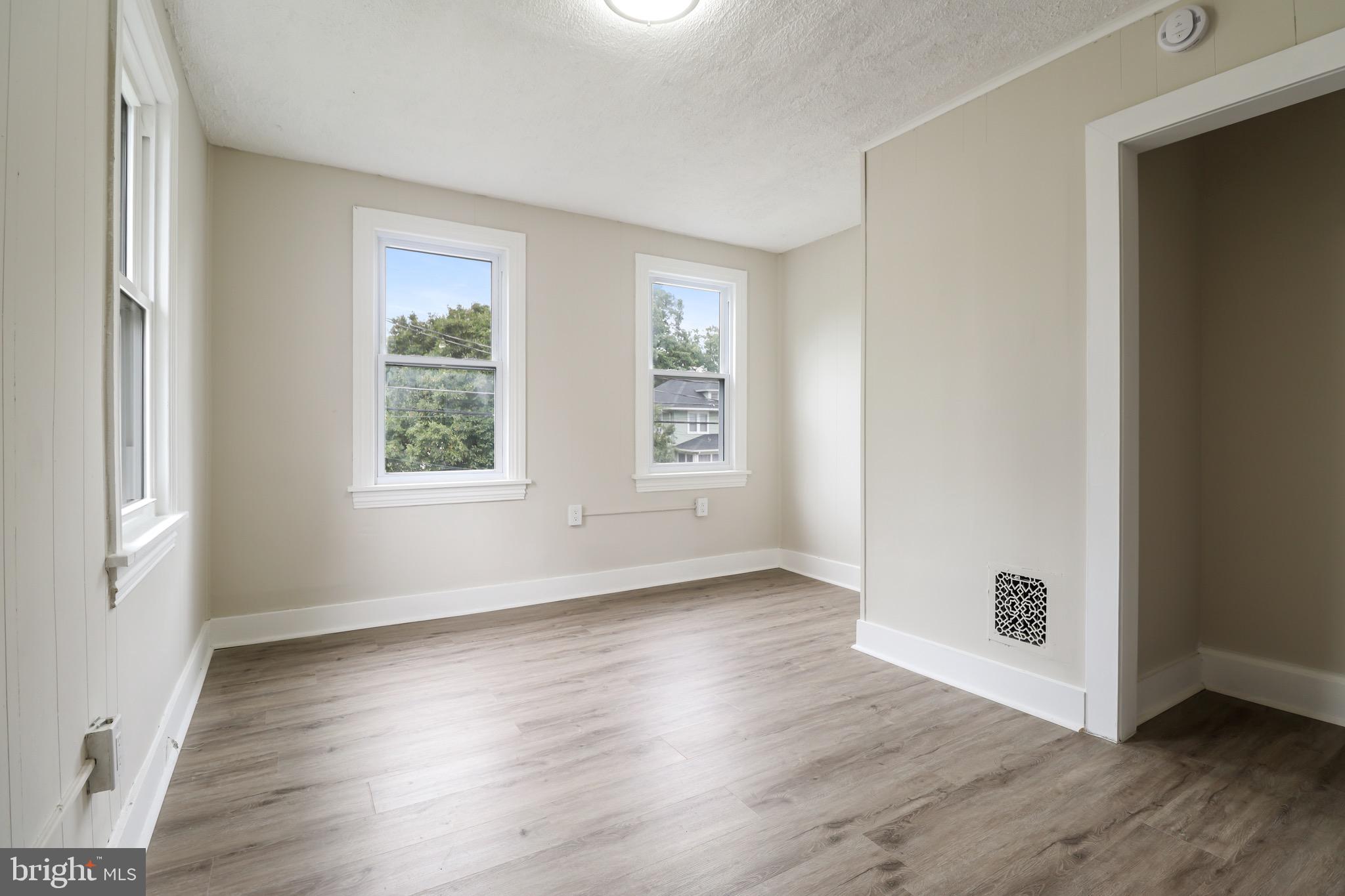 116 8th Street Salem, NJ 08079 - Photo 13 of 16 an empty room with wooden floor and windows