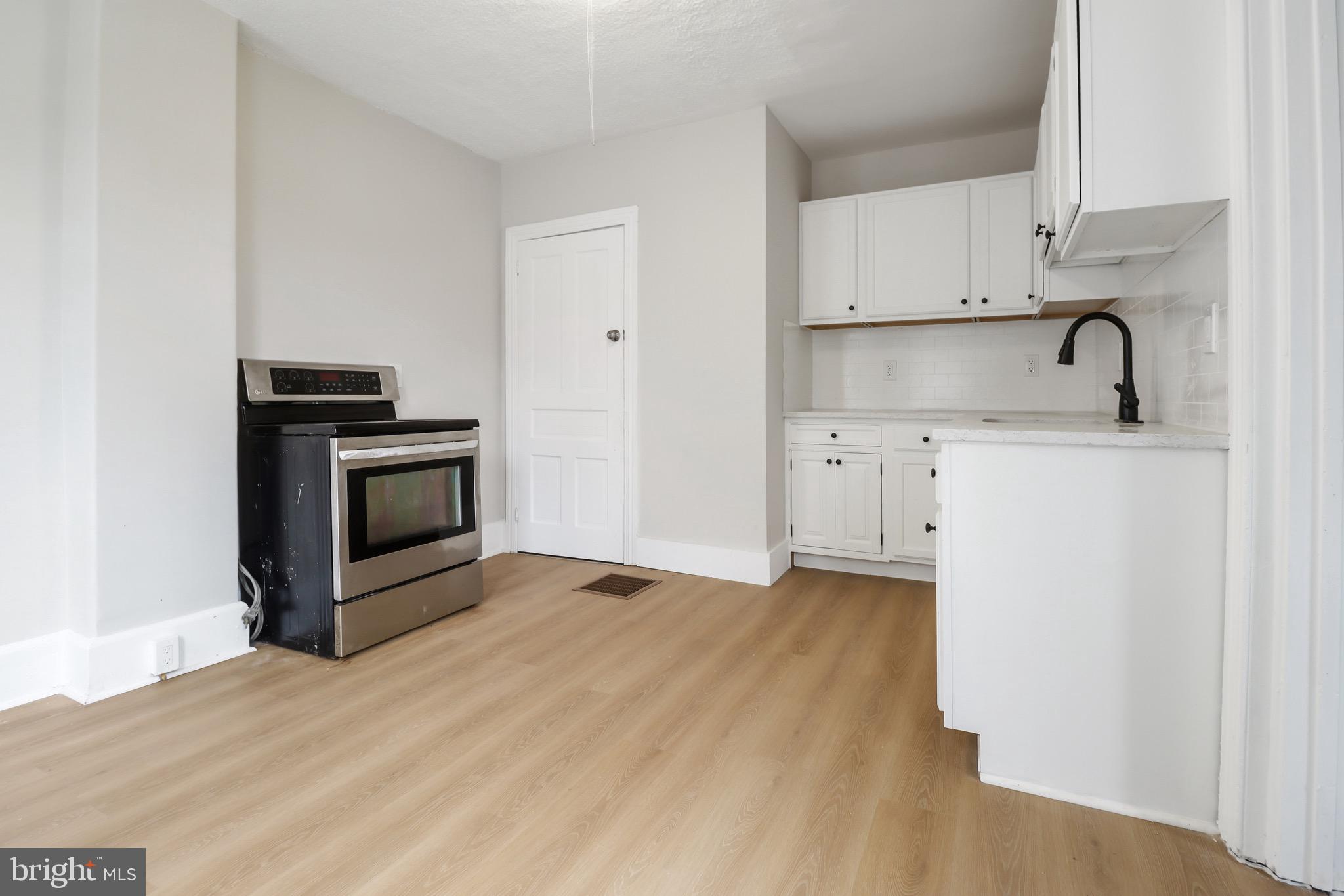 116 8th Street Salem, NJ 08079 - Photo 15 of 16 a kitchen with stainless steel appliances granite countertop a stove a sink and a microwave