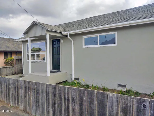 a front view of a house with wooden fence