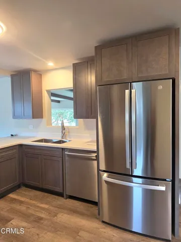 a kitchen with stainless steel appliances granite countertop a refrigerator and a sink