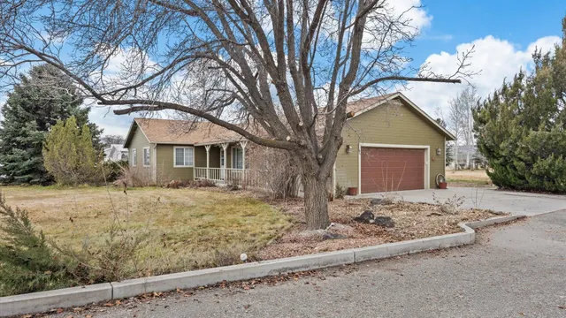 a front view of a house with a yard covered with snow