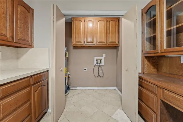a view of a kitchen with wooden cabinets and a window